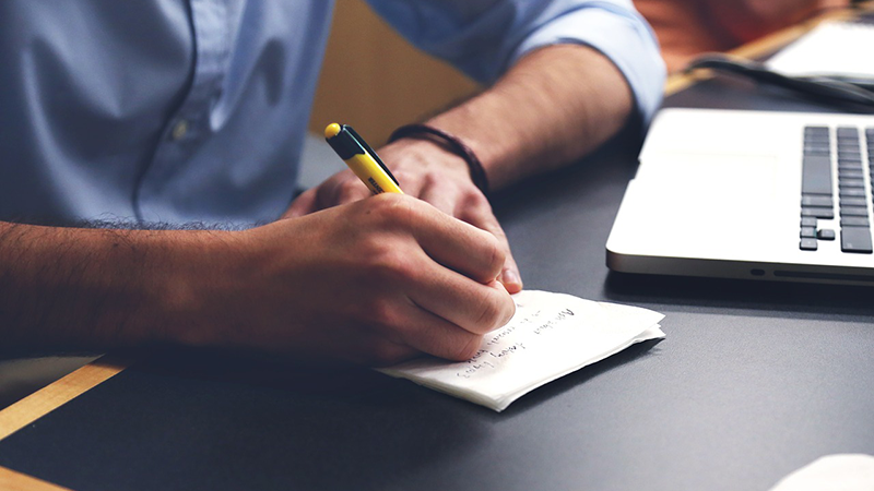 a person writing notes on a piece of paper