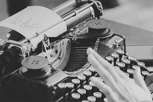 close up of woman typing on a typewriter