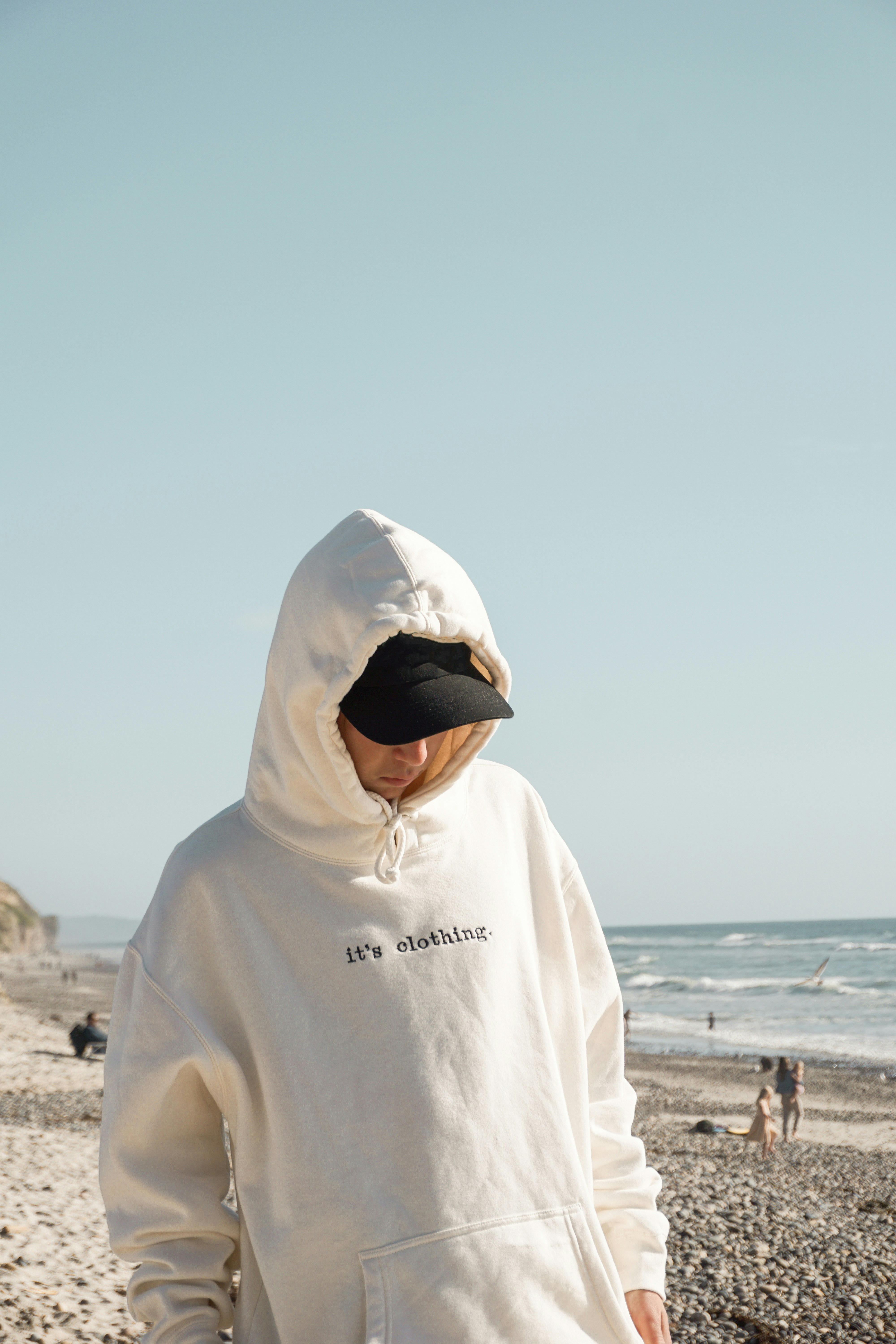 person in hoodie on the beach